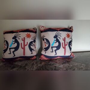 Two through pillows with embroidered sun,cuctus and flute